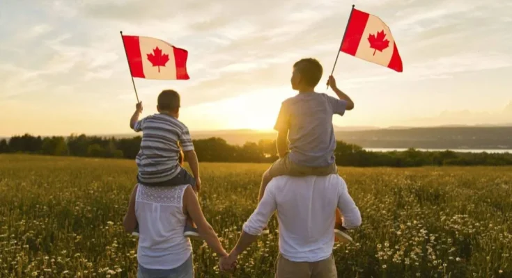 A family enjoying a sunset in Canada, holding Canadian flags, representing affordable universities and global scholarships for international and Pakistani students in 2025.
